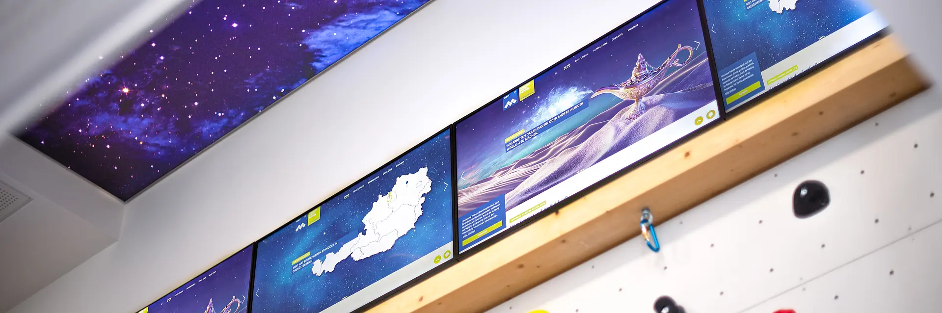 Kletterwand mit Weltraumhimmel und Screens