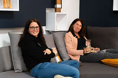 Zwei Frauen sitzen auf Sofa